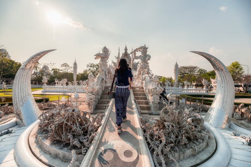Young woman walking in architecture and art of white temple at Wat Rong Khun, Chiang Rai stock photos Young woman walking in architecture and art of white temple at Wat Rong Khun, Chiang Rai stock photos