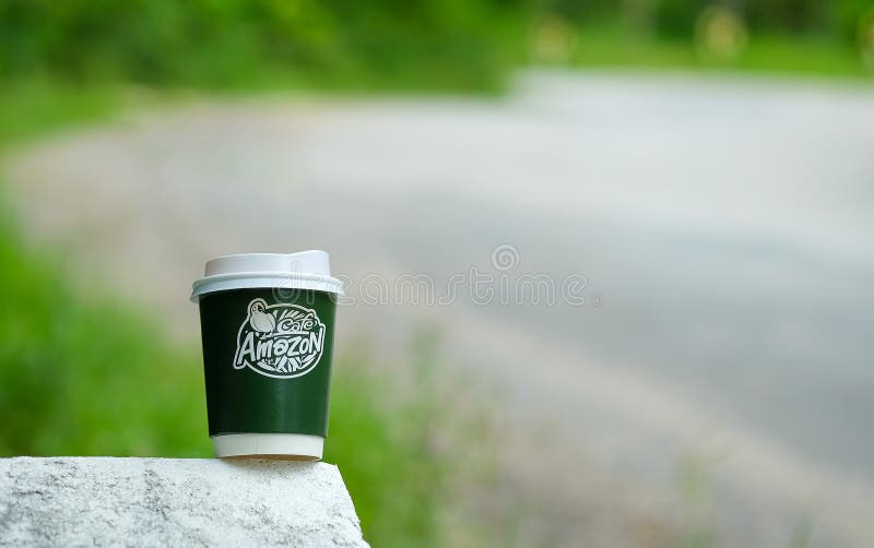 chiangmai thailand september 7 2016 amazon take away coffee cup on concrete road with blurred road background