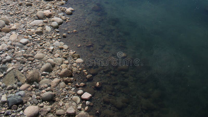 Chiaro fiume incontaminato vicino ad un letto di fiume roccioso fotografia stock libera da diritti Chiaro fiume incontaminato vicino ad un letto di fiume roccioso fotografia stock libera da diritti