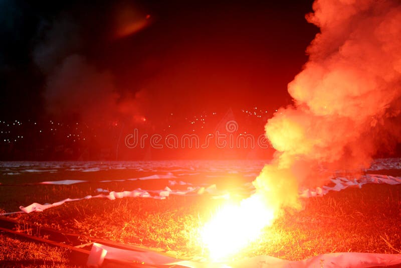 Chiarore rosso bruciante, fiamma, teppista i tifosi hanno acceso le luci e le bombe fumogene sul campo da calcio Florida bruciant immagini stock Chiarore rosso bruciante, fiamma, teppista i tifosi hanno acceso le luci e le bombe fumogene sul campo da calcio Florida bruciant immagini stock