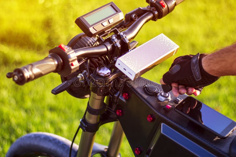 Chiave di accensione di tornitura della mano dell'uomo su ebike immagine stock libera da diritti Chiave di accensione di tornitura della mano dell'uomo su ebike immagine stock libera da diritti