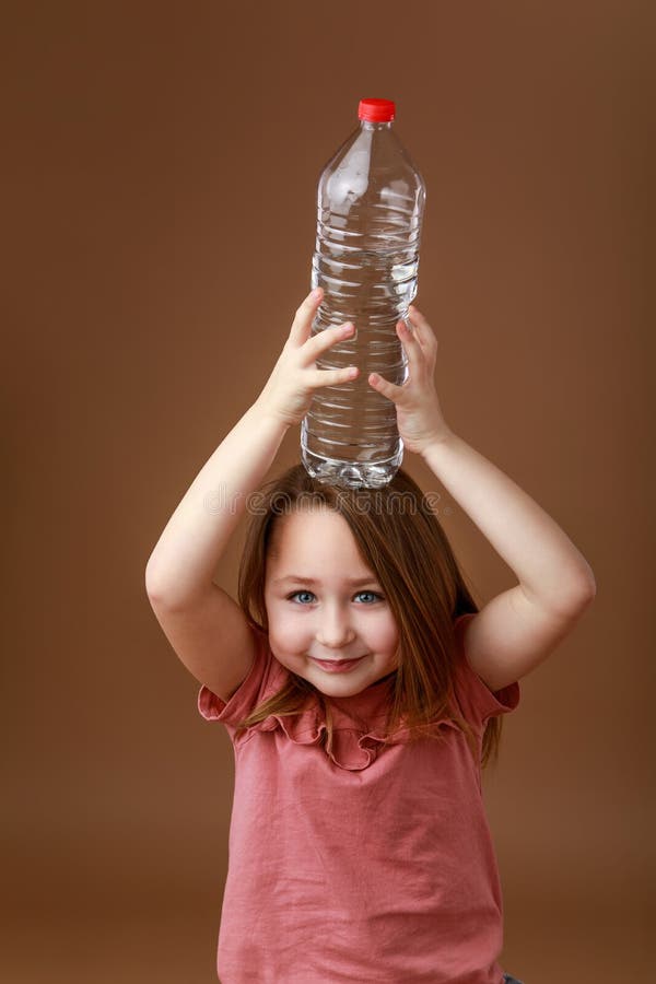 Chica Con Una Botella De Agua En La Cabeza Foto de archivo