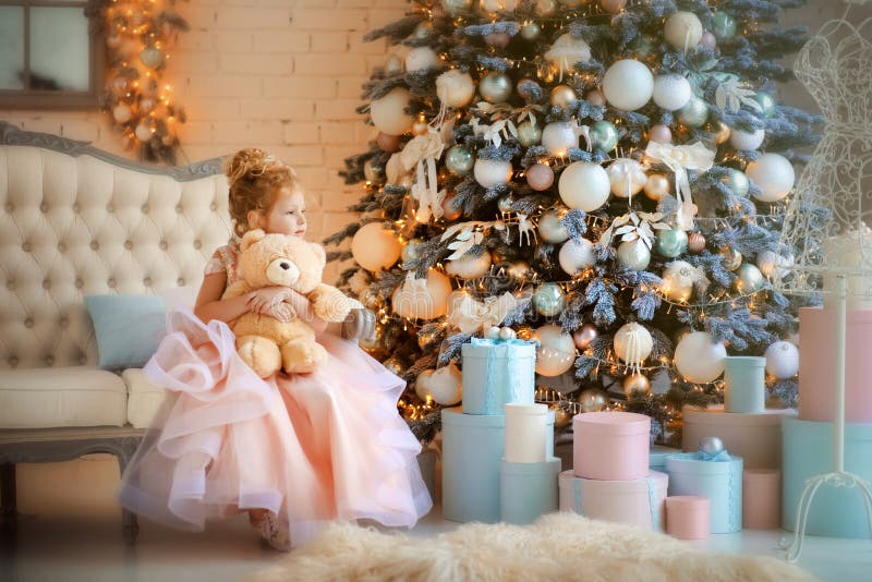 Chica de 5 años con hermoso vestido rosa claro con cremoso oso de peluche en tiempos de Navidad fotos de archivo libres de regalías Chica de 5 años con hermoso vestido rosa claro con cremoso oso de peluche en tiempos de Navidad fotos de archivo libres de regalías