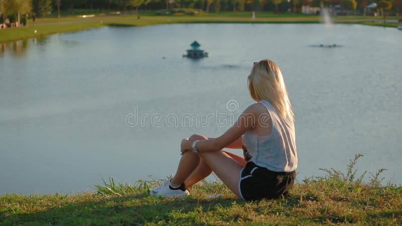 Chica delgada sentada en la colina y mira la belleza del asombroso paisaje pictórico de la ciudad de estilo europeo con hermoso l