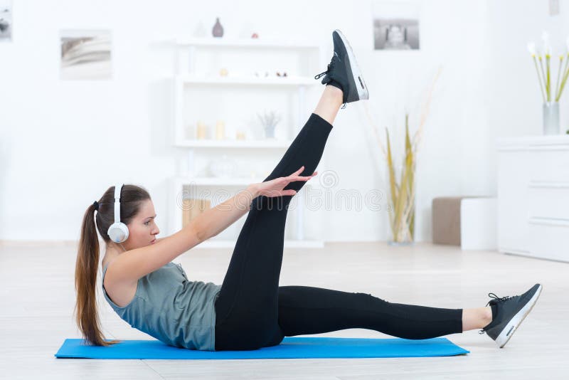 Chica deportiva delgada haciendo ejercicios de yoga en interiores fotografía de archivo