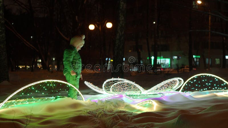 Chica está feliz de ver iluminación nocturna en el parque de invierno almacen de video