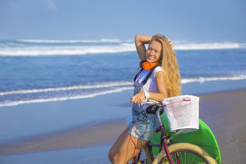 Chica joven con la tabla hawaiana y la bicicleta imágenes de archivo libres de regalías Chica joven con la tabla hawaiana y la bicicleta imágenes de archivo libres de regalías