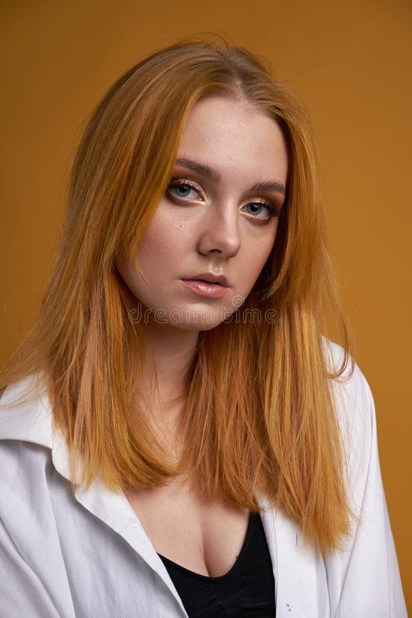 Chica joven elegante con el pelo rizado, sonriendo lindo, presentando, en fondo amarillo fotografía de archivo libre de regalías Chica joven elegante con el pelo rizado, sonriendo lindo, presentando, en fondo amarillo fotografía de archivo libre de regalías