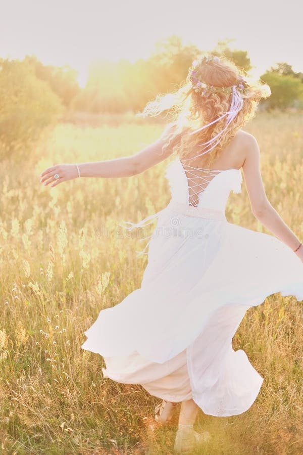 Chica joven en un vestido blanco en el prado Mujer en un vestido largo hermoso que presenta en el jardín Novia imponente en un ve fotos de archivo libres de regalías Chica joven en un vestido blanco en el prado Mujer en un vestido largo hermoso que presenta en el jardín Novia imponente en un ve fotos de archivo libres de regalías