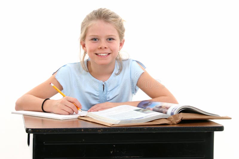 Chica joven hermosa que se sienta en el escritorio de la escuela imagen de archivo libre de regalías