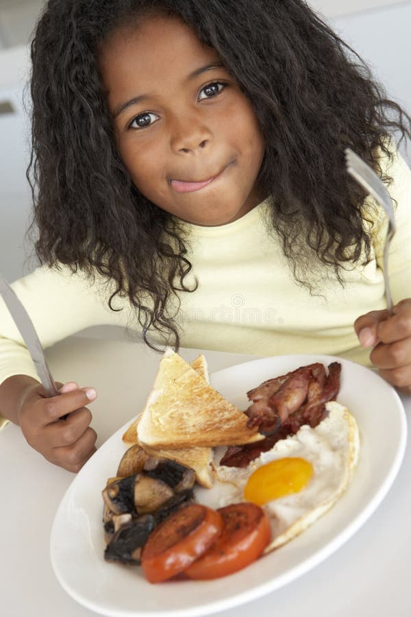 Chica joven que come el desayuno malsano foto de archivo Chica joven que come el desayuno malsano foto de archivo
