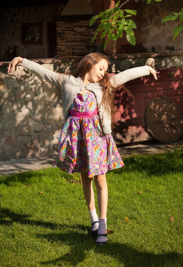 Chica joven que estira y que baila en la yarda foto de archivo libre de regalías Chica joven que estira y que baila en la yarda foto de archivo libre de regalías