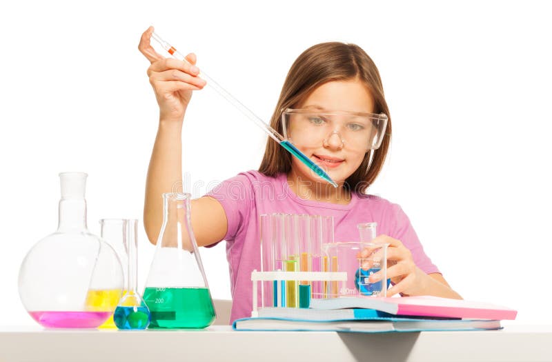 Young girl dripping from a pipette some blue reactant from the flask at the laboratory. Young girl dripping from a pipette some blue reactant from the flask at the laboratory