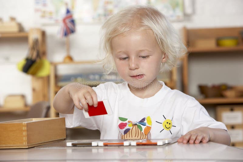 Chica joven que juega en Montessori/el pre-entrenamiento imagen de archivo libre de regalías Chica joven que juega en Montessori/el pre-entrenamiento imagen de archivo libre de regalías