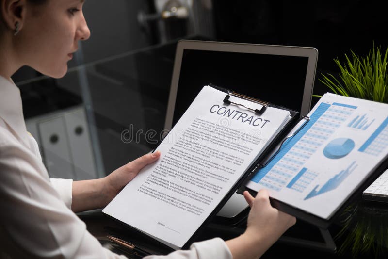 Chica joven que lleva a cabo un contrato y estadísticas firmes imagen de archivo Chica joven que lleva a cabo un contrato y estadísticas firmes imagen de archivo