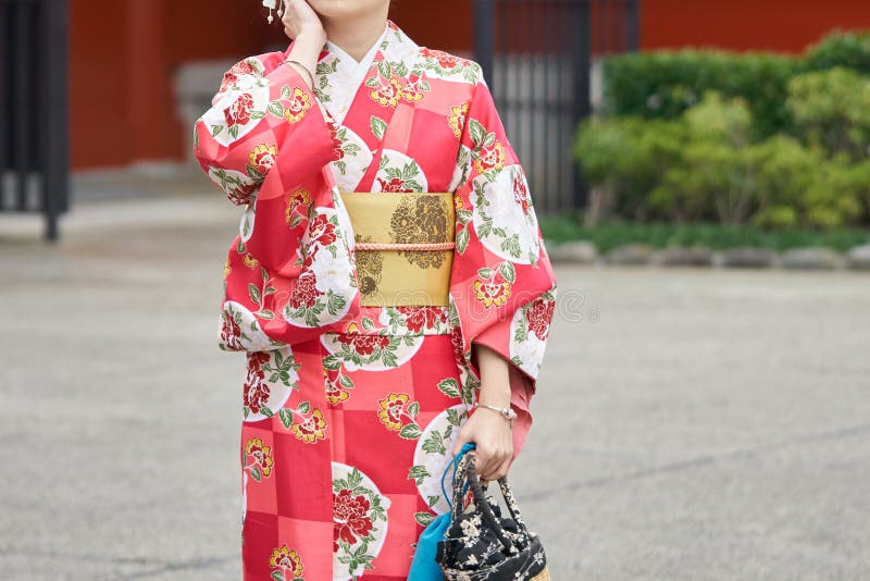 Chica joven que lleva el kimono japonés que se coloca delante del templo de Sensoji en Tokio, Japón El kimono es una ropa tradici imágenes de archivo libres de regalías Chica joven que lleva el kimono japonés que se coloca delante del templo de Sensoji en Tokio, Japón El kimono es una ropa tradici imágenes de archivo libres de regalías