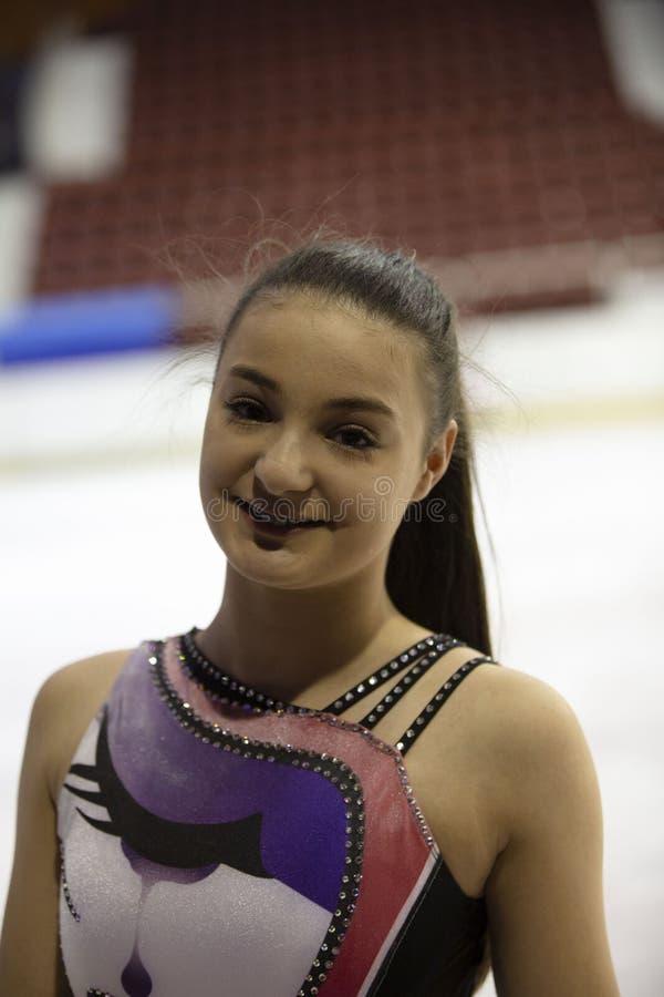 Chica joven una figura patinador en vestido púrpura en una arena del hielo imagen de archivo Chica joven una figura patinador en vestido púrpura en una arena del hielo imagen de archivo