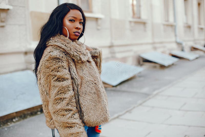 Chica negra elegante en una ciudad foto de archivo
