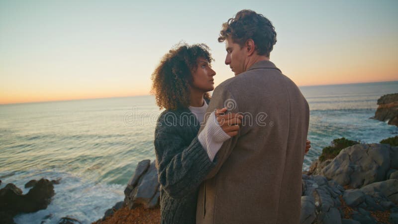 Chica rizada abrazando a novio en el cierre de la costa de la tarde. amantes abrazándose juntos almacen de metraje de vídeo