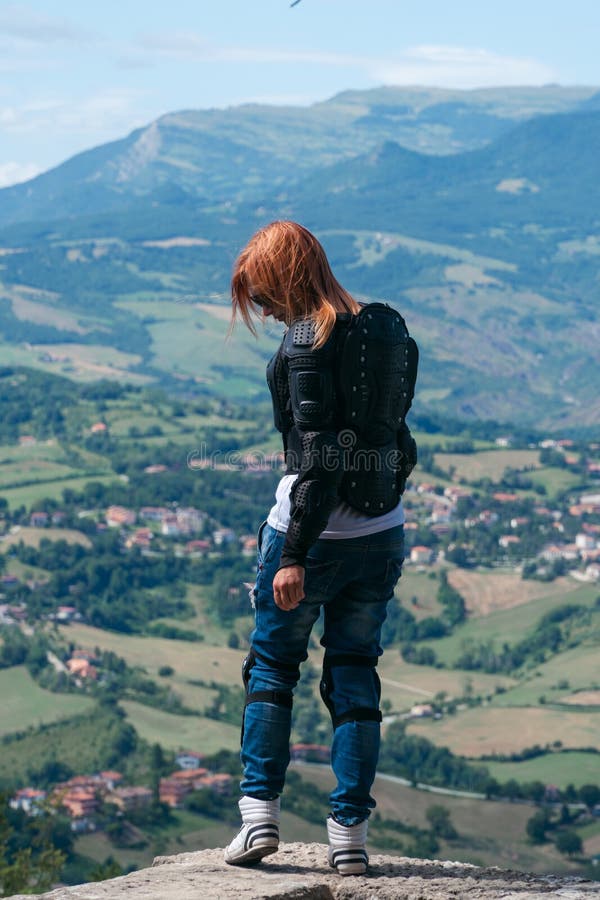 Chica Vestida Con Un Traje De Moto Protección Corporal De Tortugas Y Rodillas Almohadillas En El Borde De La Cima De La Montaña V Foto de archivo - Imagen de