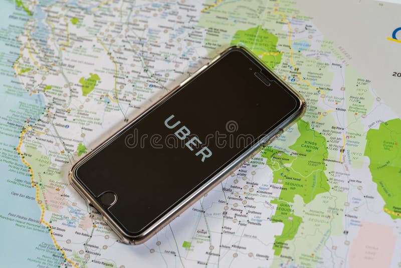 Chicago, IL, Etats-Unis, Feb-12,2017, Smartphone avec une application d'Uber sur l'écran et une carte sur une table pour l'usage éditorial seulement