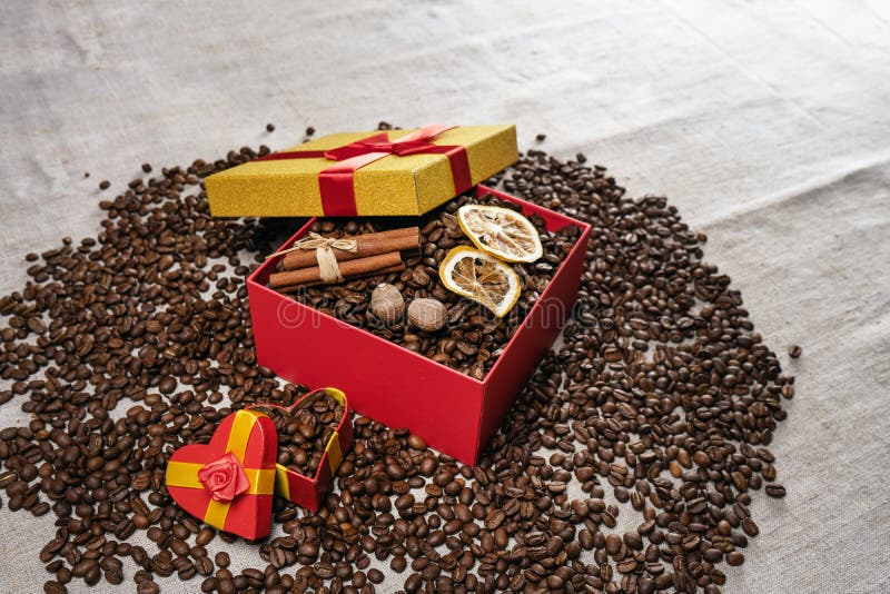 Chicchi di caffè sciolti, contenitore di regalo con i chicchi di caffè secchi del limone e bastoni di cannella Copi lo spazio immagini stock Chicchi di caffè sciolti, contenitore di regalo con i chicchi di caffè secchi del limone e bastoni di cannella Copi lo spazio immagini stock