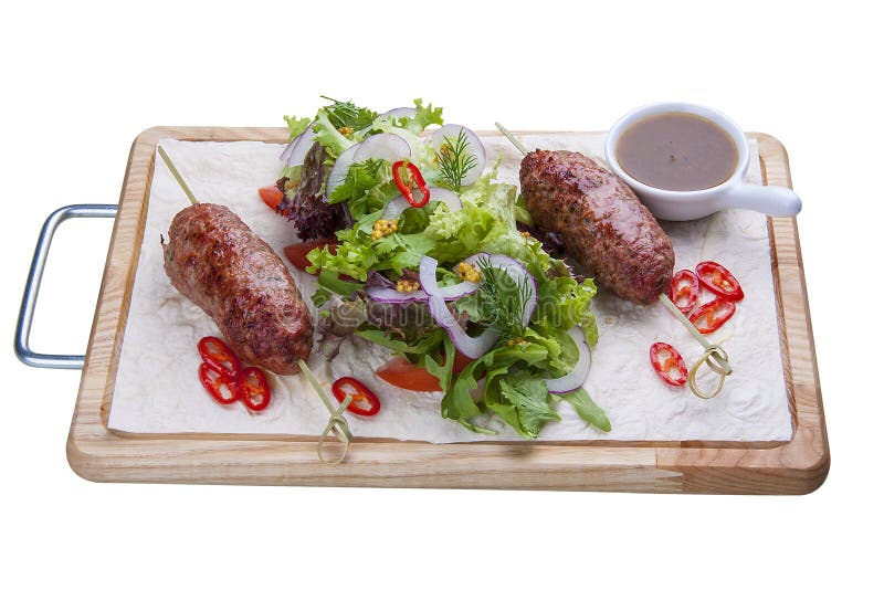 Chiche-kebab d'agneau avec la salade mixte sur un conseil en bois photo stock Chiche-kebab d'agneau avec la salade mixte sur un conseil en bois photo stock