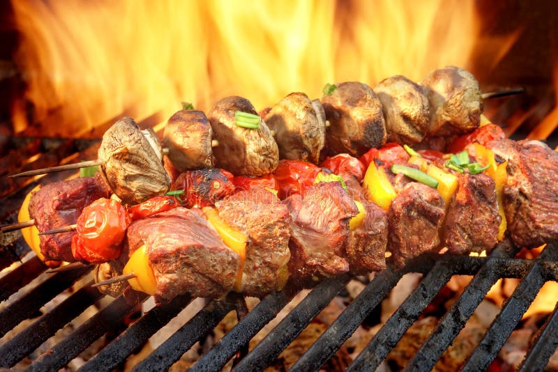 Spit Roast Beef Kebabs On The Hot Flaming BBQ Grill Close-up. Spit Roast Beef Kebabs On The Hot Flaming BBQ Grill Close-up