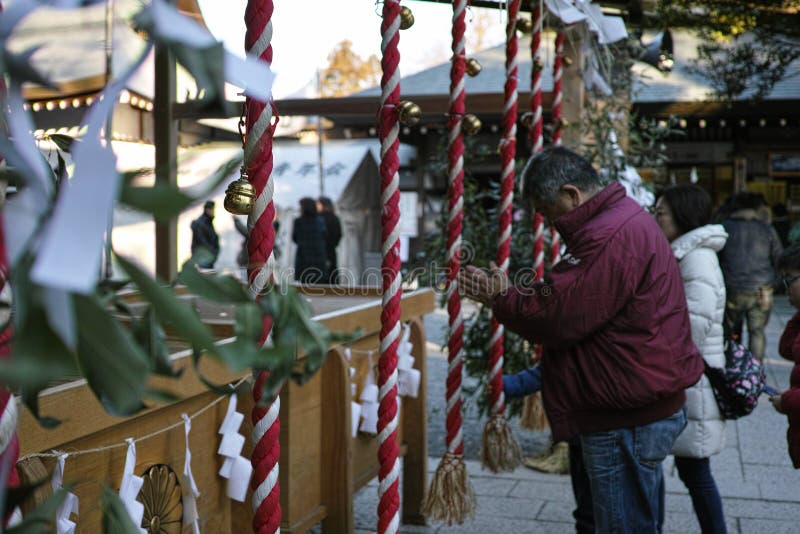 Chichibu, Japan - 4 1 2019: A man in prayer at a Shinto shrine in Japan. Chichibu, Japan - 4 1 2019: A man in prayer at a Shinto shrine in Japan.