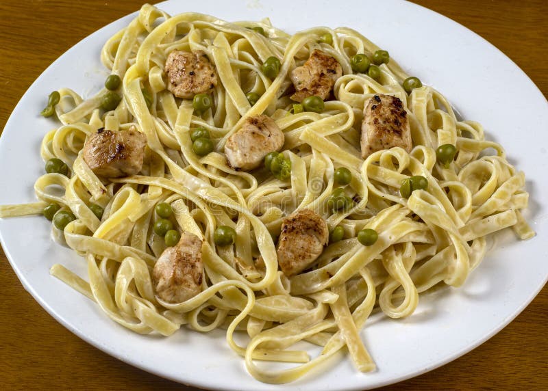 Chicken Alfredo Fettuccine with Peas and Alfredo Sauce Stock Image