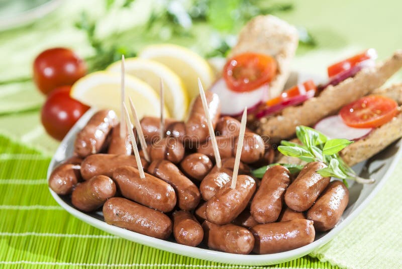 Chicken & Beef cocktail sausage with cherry tomato radish and lemon with green herb with toast bread on green red and bamboo backg. Creative food photography for royalty free stock image Chicken & Beef cocktail sausage with cherry tomato radish and lemon with green herb with toast bread on green red and bamboo backg. Creative food photography for royalty free stock image