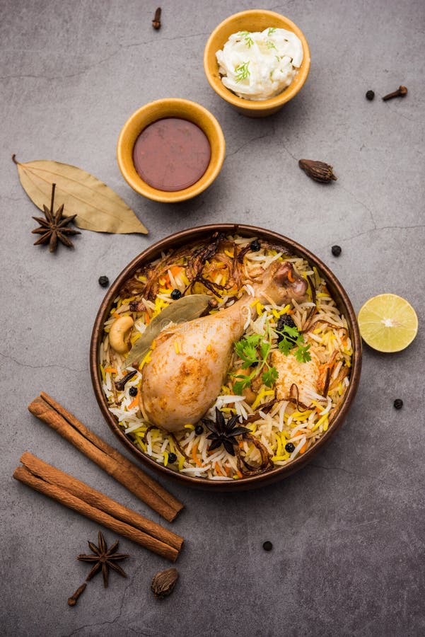 Restaurant style Spicy Chicken Biryani in wooden bowl with Raita and salan, Popular Indian or Pakistani Food. Chicken dum biryani stock images, royalty-free photos and pictures