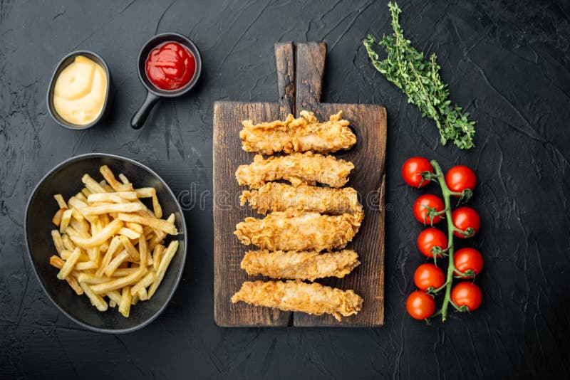 Chicken breaded fillet on black background, flat lay stock image