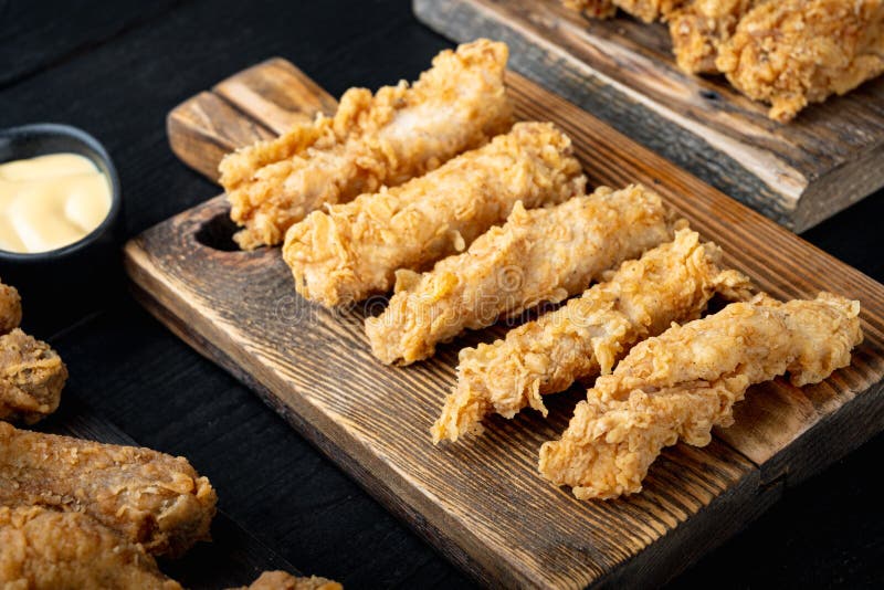 Chicken breaded fillet on black wooden table royalty free stock photo