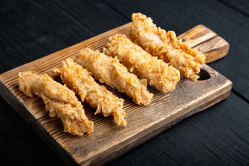 Chicken breaded fillet on black wooden table stock photography