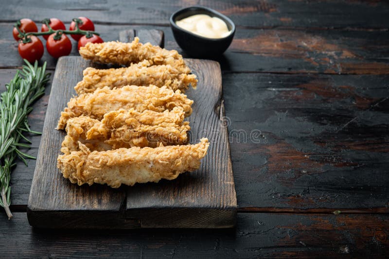 Chicken breaded fillet on old dark wooden table, with copy space stock photo