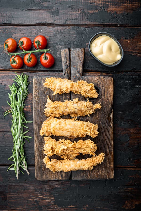 Chicken breaded fillet on old dark wooden table, flat lay stock photos