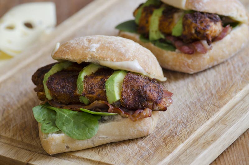 Cajun chicken burgers with spinach, avocado and grilled bacon