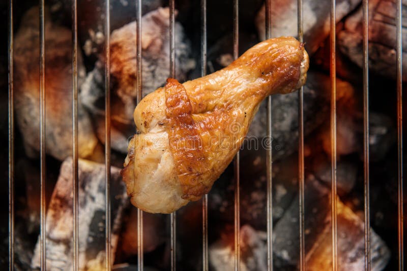 Chicken Legs Grilling Over Flames on a Barbecue. Stock Photo Image of