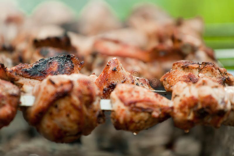 Chicken meat grilled on smouldering charcoal