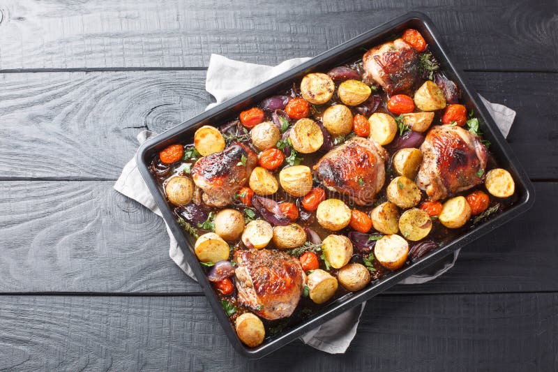 Chicken Thighs Baked with Potatoes, Garlic, Onions and Tomatoes Close