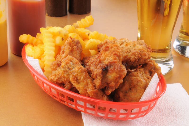 A basket of chicken wings and french fries royalty free stock images.