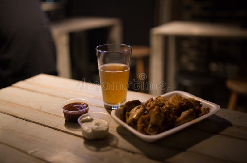 Chicken Wings, Beer, Sauces on the Table in the Pub Stock Photo - Image