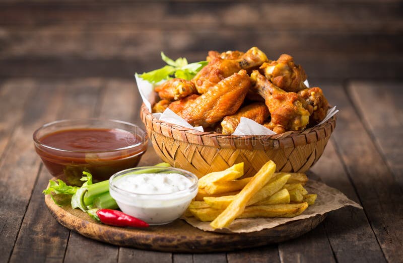 Chicken wings with dips on the wooden table