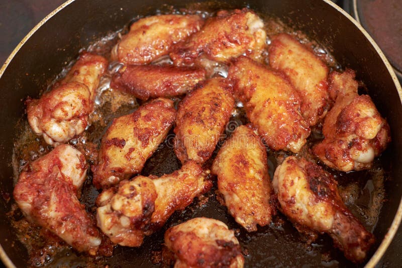 Chicken wings fried in pan with hot oil, homemade food.