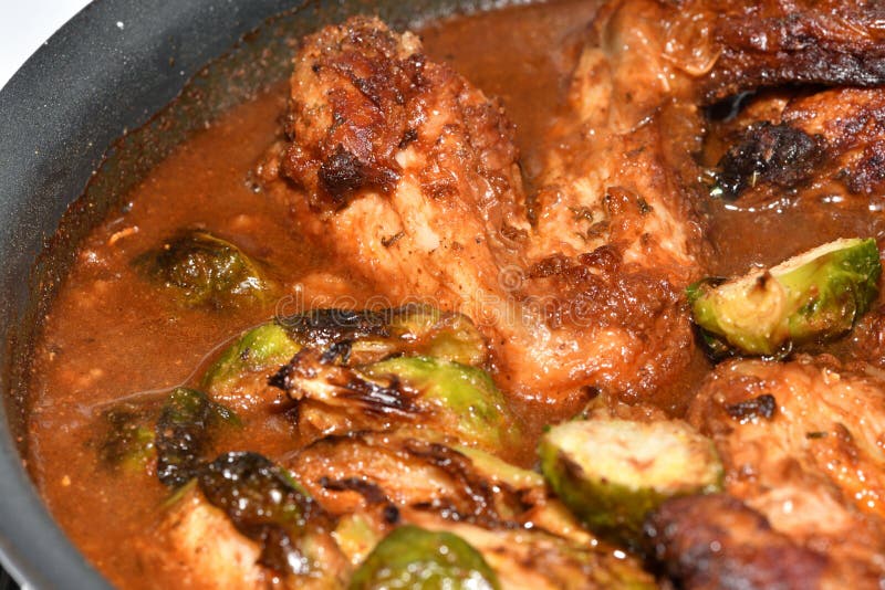 Chicken Wings in Gravy with Brussel Sprouts, Being Cooked. Stock Photo