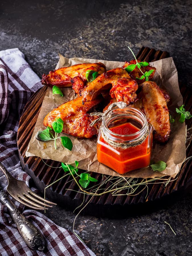 Chicken Wings With Hot Tomato Sauce On A Chopping Board Stock Image