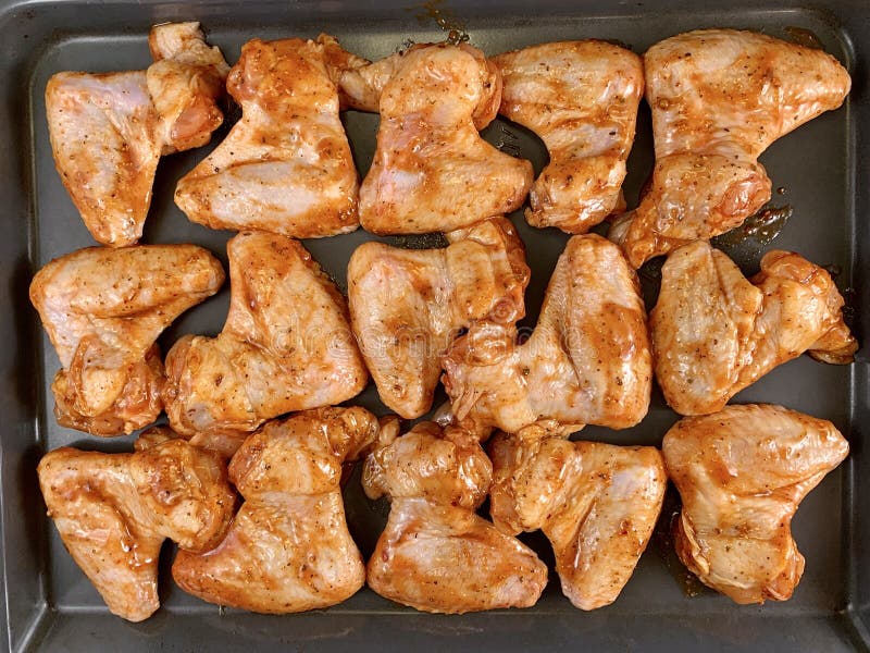 Chicken wings in a marinade on a baking sheet. Cooking chicken with spices in the oven. Fried Chicken Legs and Wings Recipe royalty free stock photo Chicken wings in a marinade on a baking sheet. Cooking chicken with spices in the oven. Fried Chicken Legs and Wings Recipe royalty free stock photo