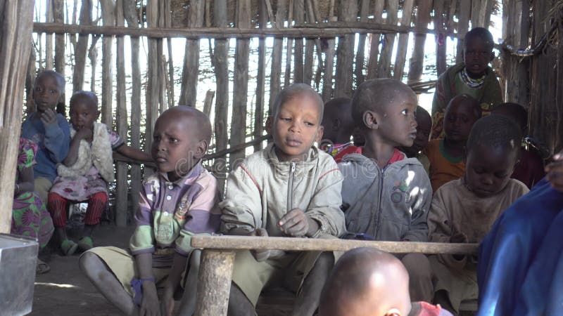 Chicos de la tribu maasai sentados en clase de escuela improvisada niños africanos cerca