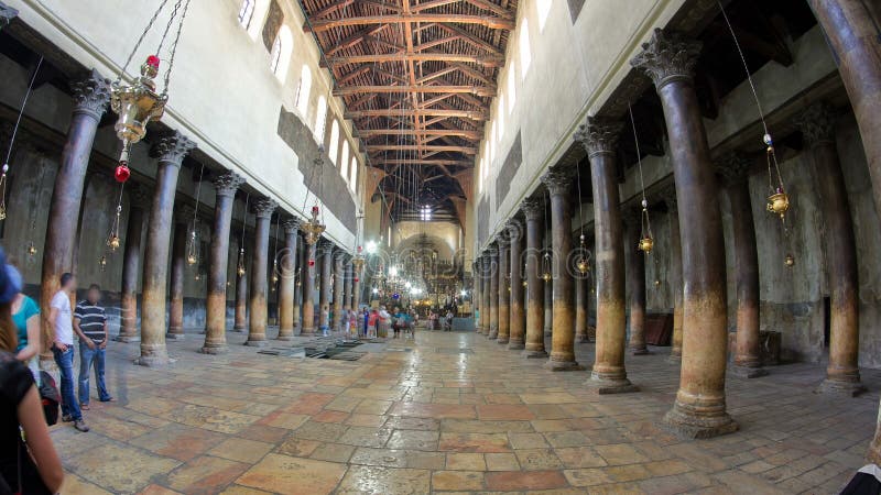 Church of the Nativity interior with hall colonnade, altar and icon lamps hanging on long chain in Bethlehem timelapse hyperlapse. People inside. Church of the Nativity interior with hall colonnade, altar and icon lamps hanging on long chain in Bethlehem timelapse hyperlapse. People inside